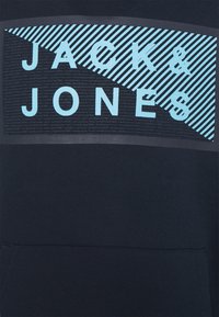 Mörkblå hoodie med ett diagonalt mönster i ljusblått med texten "JACK & JONES" och randiga mönster. Mjuk, blandad bomullstyg.