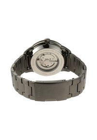 Montre en acier inoxydable avec une finition noire polie, mouvement automatique et bracelet en métal brossé, dotée d'un fond de boîtier transparent.