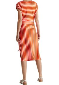 Czerwona i biała sukienka w paski z krótkimi rękawami, dopasowaną talią, spódnicą do kolan i bocznym rozcięciem; wykonana z miękkiego, elastycznego materiału.