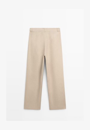 Beżowe spodnie o prostych nogawkach z szlufkami na pasek, przednimi zakładkami i czystym, minimalistycznym designem przedstawione na białym tle.