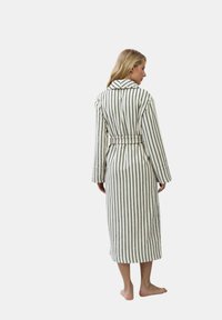 Biały szlafrok w czarne pionowe paski, z kołnierzem, długimi rękawami i paskiem w talii. Miękka, teksturowana tkanina.