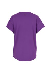 Lila kurzärmliges Oberteil aus leichtem Stoff. Verfügt über einen runden Halsausschnitt und ein kleines Logo-Detail nahe der Rücken-Schulternaht.