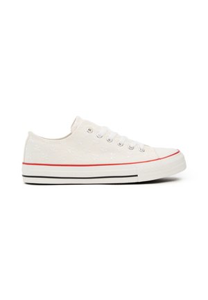 Zapatillas de lona blancas con un patrón floral, acento rojo en la suela, puntera redonda y franja negra, con cinco ojales y cordones blancos.