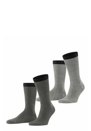 Drei Paar Socken mit schwarz-weißen horizontalen Streifen, gerippten schwarzen Bündchen und glatter Textur, die in der Höhe variieren.