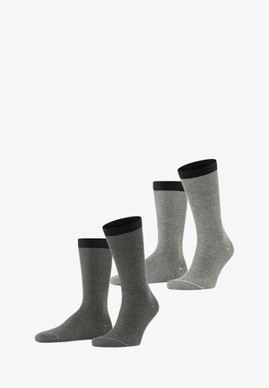 Drei Paar Socken mit schwarz-weißen horizontalen Streifen, gerippten schwarzen Bündchen und glatter Textur, die in der Höhe variieren.