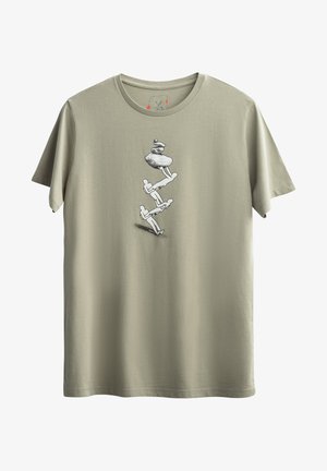 Olijfgroen katoenen T-shirt met een zwart grafisch ontwerp van opgestapelde figuren en stenen aan de voorkant. Korte mouwen ontwerp.