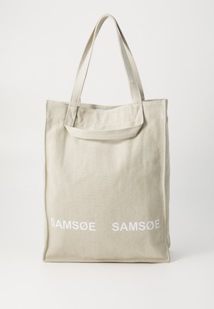 Canvas tote bag in light beige with dual handles, featuring "SAMSOE" logo in white printed on the front. Rectangular shape with simple design.