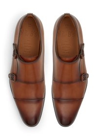 Brune læder dobbelt monk strap sko med en poleret overflade, afrundet tå og dekorative spænde accenter. Tekstureret inderside med mærke.
