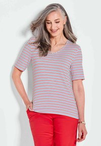 T-shirt à manches courtes à rayures blanches avec des rayures rouges et bleues, avec un décolleté en V. Associé à un pantalon rouge, texture de tissu lisse.