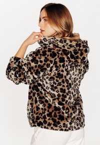 Hoodie in stampa leopardata in morbido e soffice tessuto; presenta un cappuccio con cordino, vestibilità comoda e polsini a coste. Principalmente beige con macchie nere e marroni.