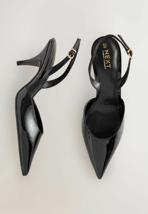 Mustat patenttinahasta slingback-korot, joissa on terävät kärjet ja siro korko. Varustettu säädettävällä hihnalla, jossa on kullanvärinen solki.