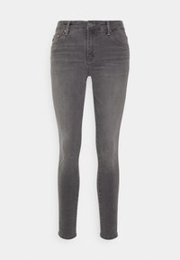 Jeans skinny grises de denim, con una cintura de altura media, cinco bolsillos, un ligero desgastado y una cremallera con cierre de botón.
