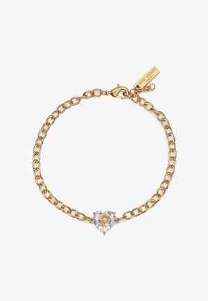 Bracciale con catena d'oro con un gioiello centrale a forma di cuore trasparente e una piccola targhetta incisa con "Kurt Geiger London" vicino alla chiusura.