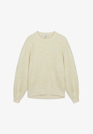 Jasnożółta bluza z wypukłym wzorem kwiatowym, okrągłym dekoltem i długimi rękawami. Miękka faktura i luźny krój. Dolny brzeg jest lekko zaokrąglony.