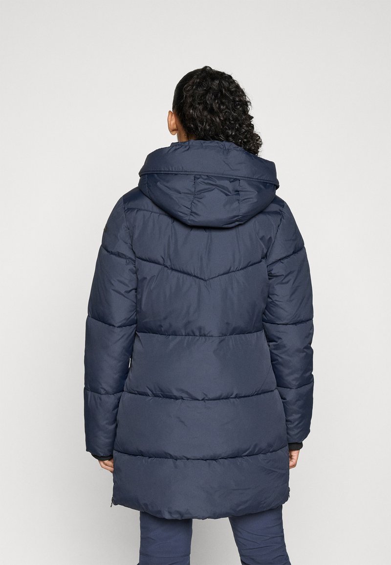 Manteau rembourré bleu marine avec une capuche, présentant des sections matelassées et un dos légèrement plus long. Le matériau semble lisse et isolé.