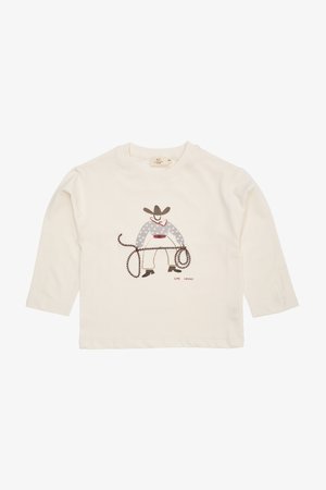 Kreemivärvi pikade varrukatega T-särk, millel on cowboy illustreerimine lassoga, rõhutatud täppidega ja värvikas vöö.