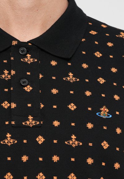 Μαύρο πόλο μπλουζάκι με πορτοκαλί γεωμετρικό σχέδιο. Σημαντικά στοιχεία περιλαμβάνουν μερικά μαύρα κουμπιά και κεντητό σχέδιο ενός πλοίου.