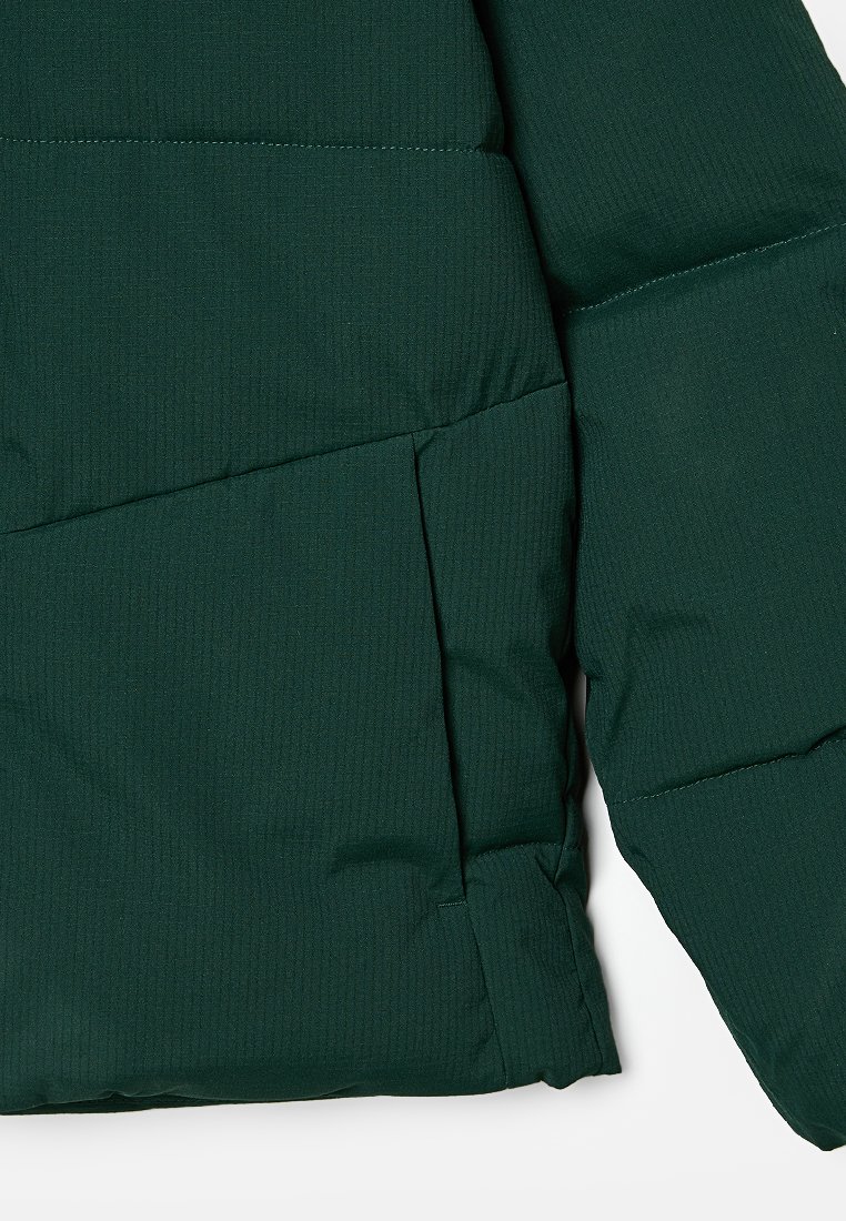 Dunkelgrüne Daunenjacke mit strukturiertem Stoff, horizontalen Nähten und einer Seitentasche. Glatte Oberfläche mit weicher Isolation.