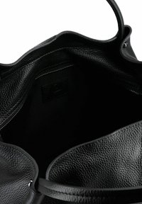 Borsa tote in pelle nera con superficie testurizzata. La progettazione con apertura superiore rivela un interno spazioso con fodera nera e un piccolo tag del logo all'interno.