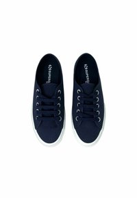 Marinefarbene Segelschuhe aus Canvas mit weißen Gummisohlen, runden Schnürsenkeln und Metallösen. Markenlogo auf der Innensohle sichtbar.