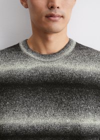 Grauer und schwarzer Strickpullover mit rundem Halsausschnitt, der ein Verlaufsmuster und strukturiertes Material aufweist. Nahaufnahme des Halsausschnitts.