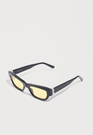 Črna pravokotna sončna očala z rumenimi odtenki leč in srebrnimi poudarki na stranicah, na preprostem svetlem ozadju.