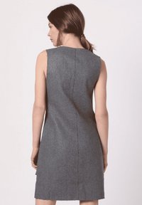 Vestido gris sin mangas hecho de una tela texturizada con un corte estilizado, que presenta una costura trasera sutil y sin adornos adicionales.
