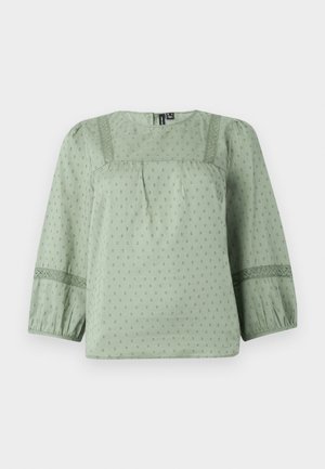 Světle zelená blůza vyrobená z měkké tkaniny, která má strukturovaný vzor, kulatý výstřih a tříčtvrteční balónové rukávy s krajkovými detaily.