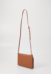 Kleine braune Leder-Crossbody-Tasche mit strukturiertem Finish, ausgestattet mit goldfarbenen Beschlägen und einem verstellbaren Tragegurt. Reißverschluss oben.