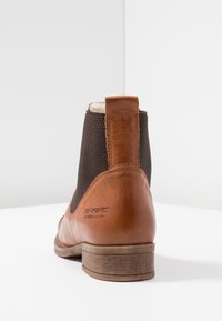 Czarne skórzane botki za kostkę z elastycznymi bokami, teksturowanym materiałem na górze i skromnym obcasem. Szczegółowe logo na obcasie.