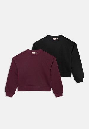 Deux sweat-shirts à col rond pliés, l’un violet foncé et l’autre noir, présentés à plat sur fond blanc.