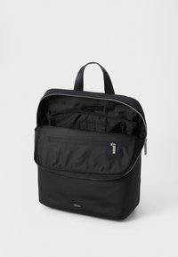 Zaino in nylon nero con chiusura a zip, texture liscia, tasca frontale, scomparti interni e dettagli in pelle.