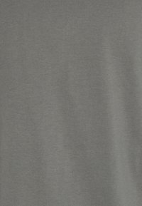 Texture de tissu gris avec un motif de tissage subtil et des plis doux, suggérant un matériau textile lisse et léger.