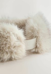 Faux fur ørevarmere i lys beige, med en blød tekstur og elastisk rem for sikker pasform. Kanterne er trimmet med længere fibre for ekstra varme.