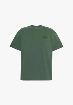 Groen Timberland T-shirt met korte mouwen, ronde hals en een klein zwart logo op de linkerborst met de tekst "Timberland opgericht 1973, VS."