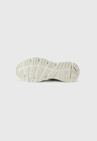Sola de sapato de cor clara com padrão de tração texturizado; apresenta um material flexível e forma curva, adequada para diversas superfícies.