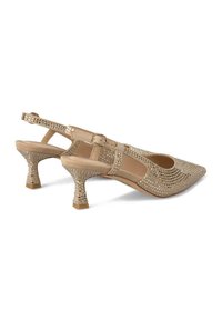 Tacchi slingback beige con punta affusolata, impreziositi da strass e con tacco a blocco testurizzato. Inclusa cinturino alla caviglia regolabile.