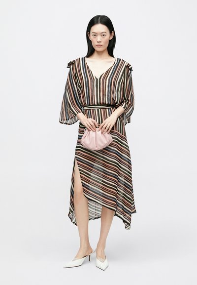 Svītraina kleita ar dziļu V-veida izgriezumu, plūstošām piedurknēm un augstu šķēlumu. Kombinēta ar rozā rokassomiņu un baltām, ar punktētu purngalu apaviem.