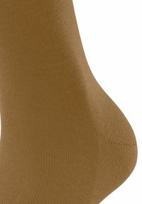 Brązowa bawełniana skarpetka o gładkiej strukturze i ciasnym splotcie, z zaokrąglonym palcem i lekko elastycznym otworem, zapewniającym dopasowane przyleganie.