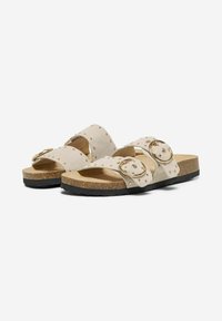 Sandali open-toe beige con due larghe cinghie, dettagli con borchie e fibbie circolari in tonalità oro. Soletta in sughero e suola in gomma nera.