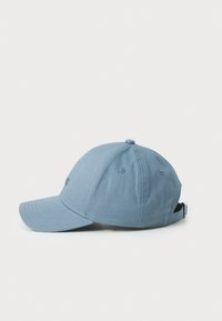 Blå bomull baseball caps med buet skjerm, seks-panel design og justerbar stropp bak. Har ventilasjonsøyler for pusteevne.