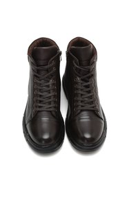 Bottines en cuir marron avec bouts ronds, texture lisse et semelles en caoutchouc foncé contrastantes, dotées de lacets et de fermetures éclair latérales.