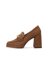 Mocassini con tacco in suede marrone, con punta quadrata, tacco spesso e dettagli in metallo dorato sulla parte superiore. Texture liscia e design minimalista.