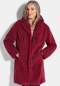 Bordeaux fleecjasjaal met een geknipt kraag, knoopsluiting aan de voorkant, zijzakken en een gestructureerde stof. Ontworpen voor warmte en comfort.