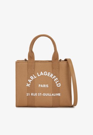 Borsa a tracolla in canvas marrone con due manici superiori, tracolla regolabile e testo stampato bianco. Presenta una forma rettangolare strutturata.