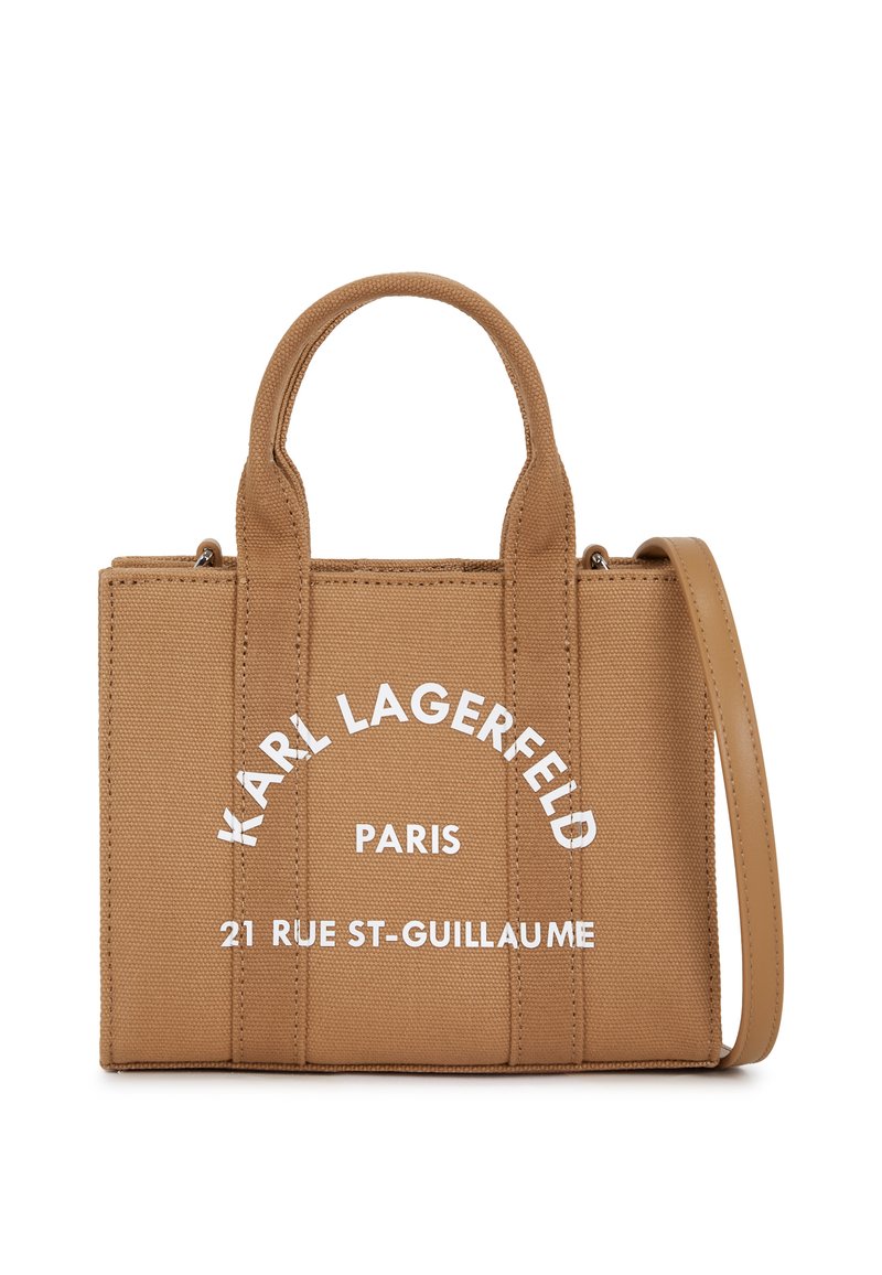 Bolso de lona marrón con dos asas superiores, correa de hombro ajustable y texto impreso en blanco. Presenta una forma rectangular estructurada.