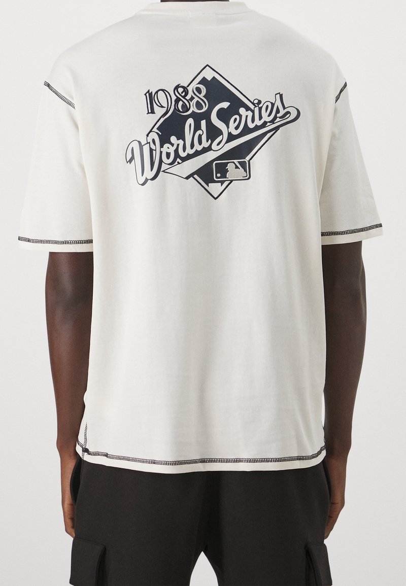 Bílý bavlněný tričko s černým grafickým designem "1988 World Series", tvar diamantu, krátké rukávy, kontrastní švy podél okrajů.