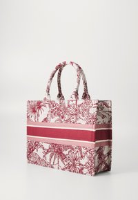 Rød og hvid mønstret tote taske med dobbelt håndtag; har blomster- og dyremotiver mod en tekstureret stof med vandrette striber.
