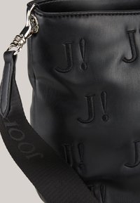 Bolso de cuero negro con patrón grabado "J!", correa de tela resistente con marca y textura suave. Herrajes de metal para el cierre.