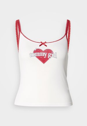 White tank top with red detail, featuring a heart-shaped graphic and "tommy girl" text. Red straps with scalloped edges and a bow accent.